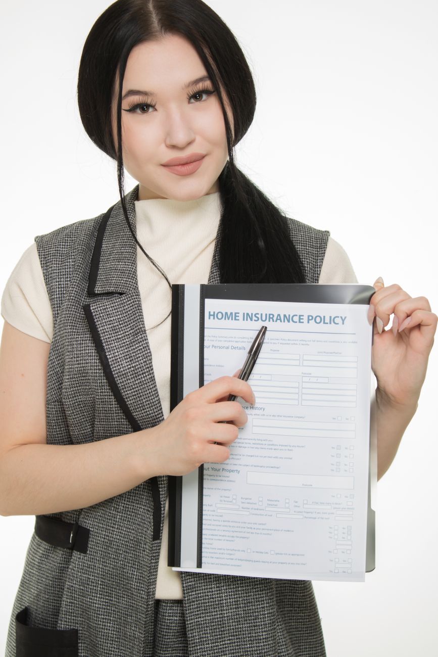 a woman showing the piece of document she is holding while looking at the camera